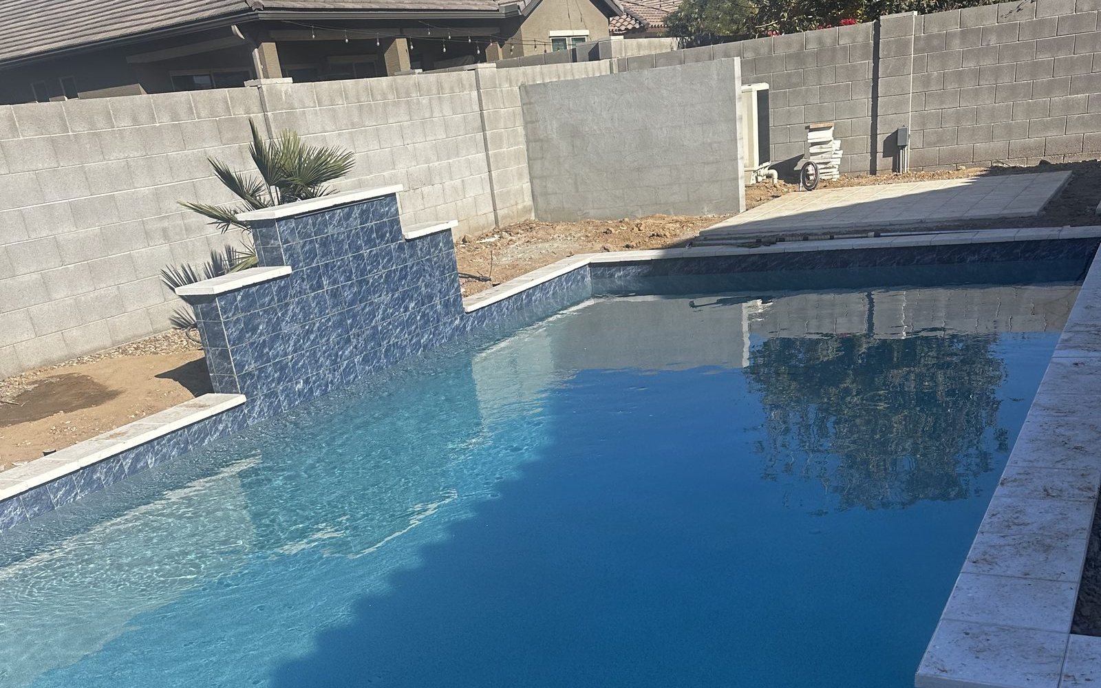 New pool with a tiled water feature built by Arizona Pool Service