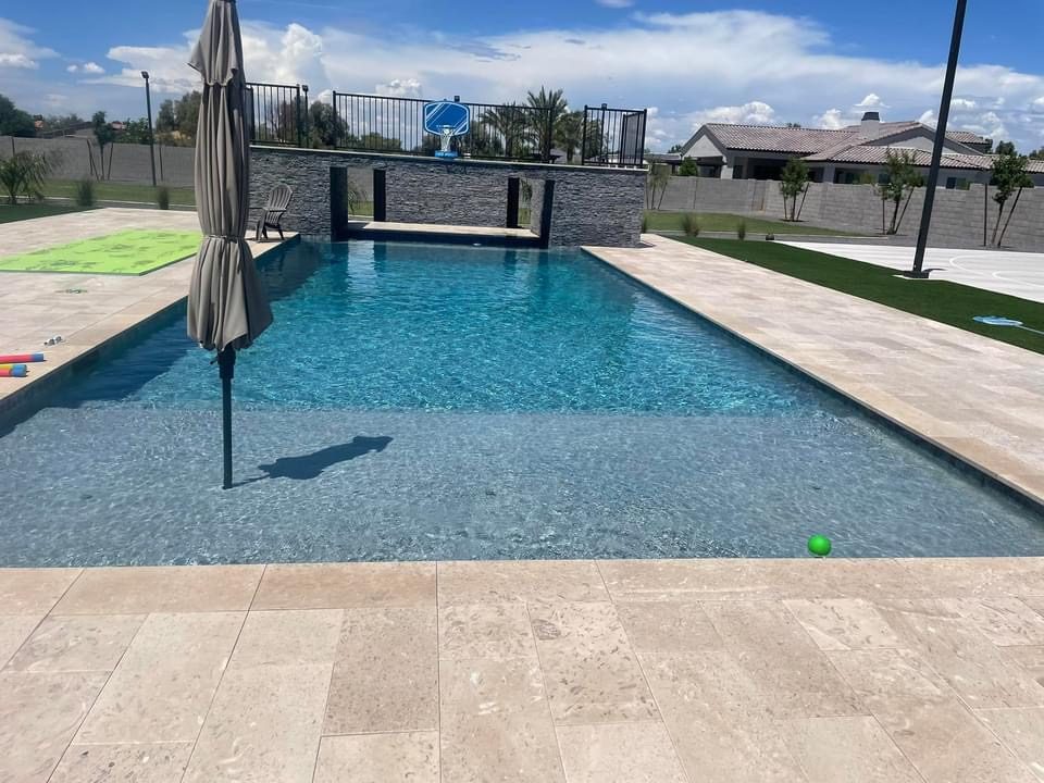 New pool built by Arizona Pool Service with a baja shelf and stone feature wall